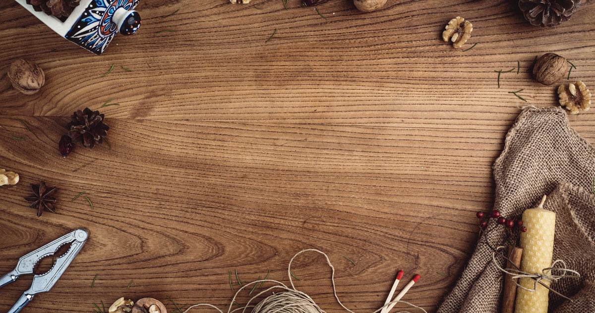 Table en bois avec noix, pommes de pin, bougie en cire d'abeille et pelote de ficelle