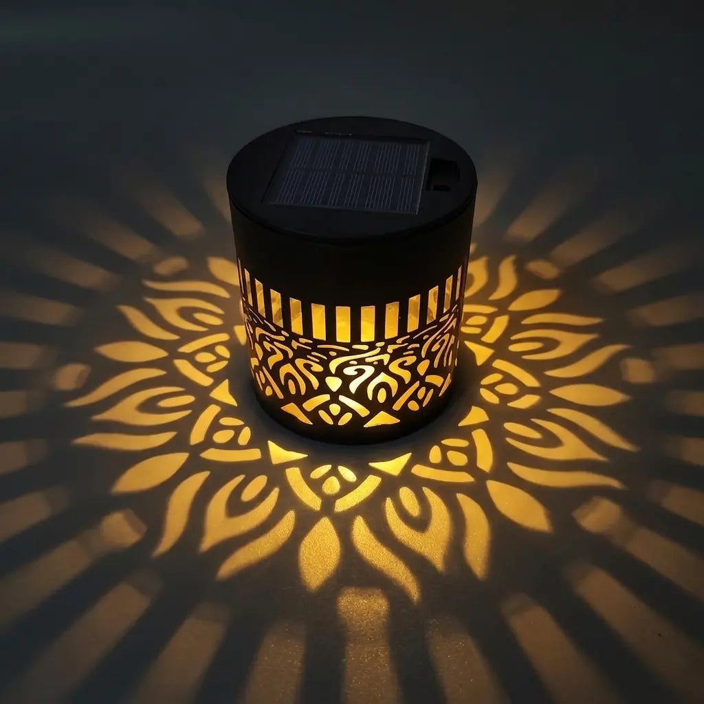 Lampe solaire Fleur de Lumière allumée de nuit, projetant un motif de fleur dorée sur le sol