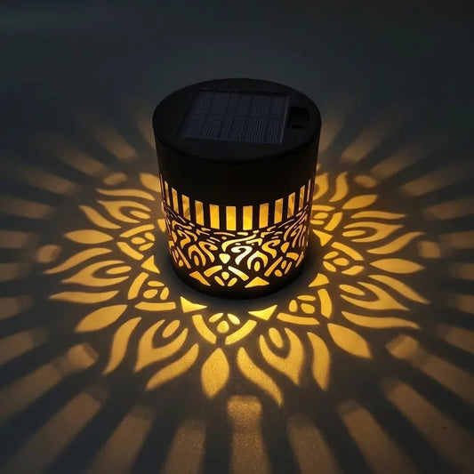 Lampe solaire Fleur de Lumière allumée de nuit, projetant un motif de fleur dorée sur le sol