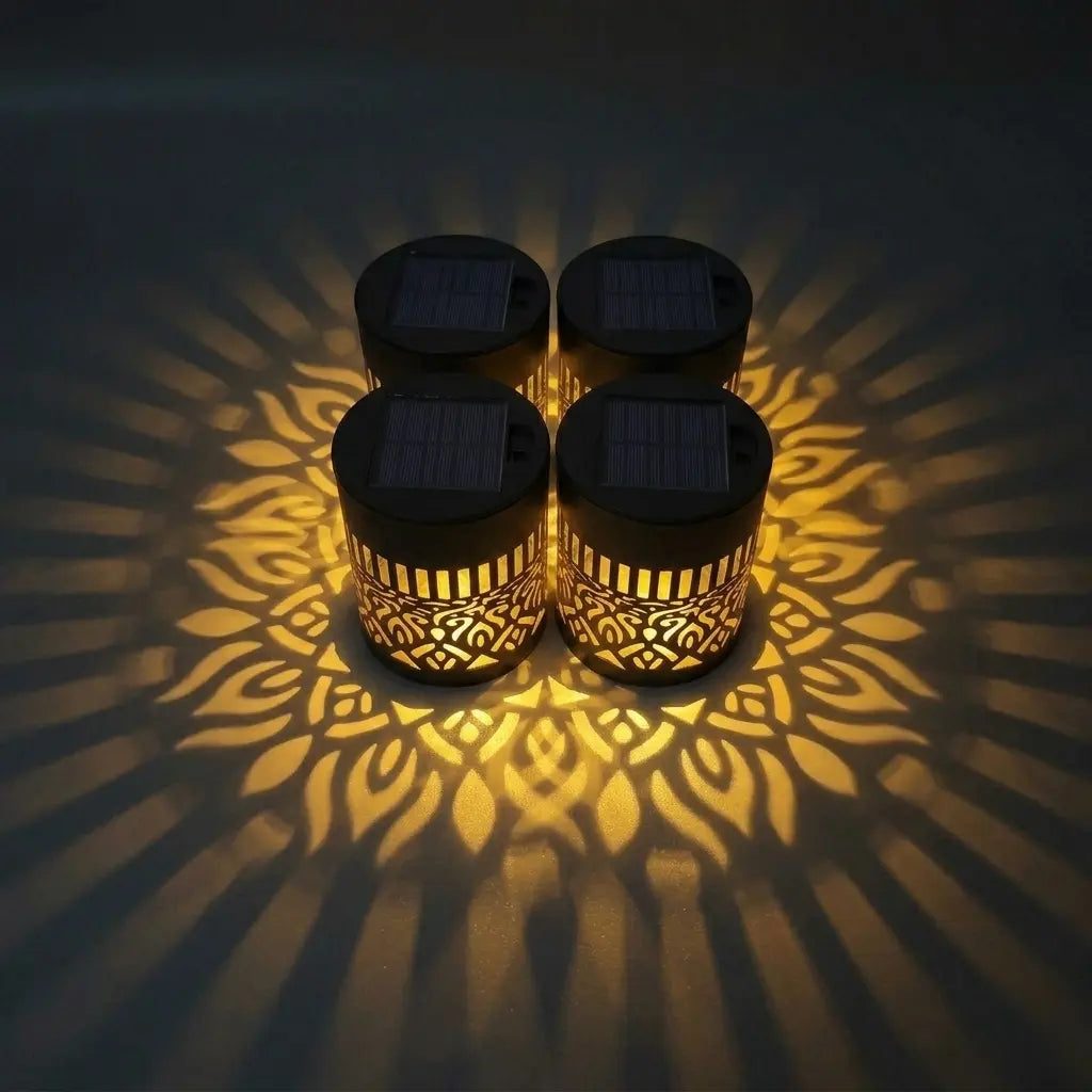 Lot de quatre lampes solaires réunies, dont la lumière forme une grande fleur dorée au sol