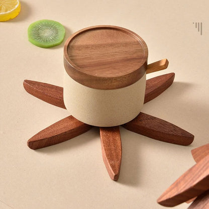 Tasse avec couvercle en bois posée sur un dessous de plat en bois en étoile
